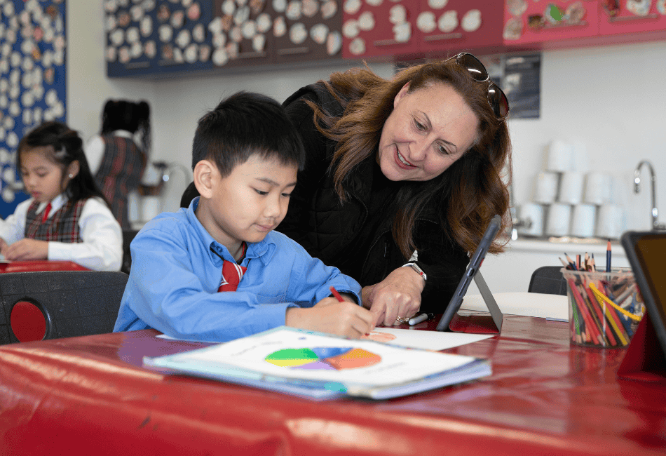A photo of a teacher sharing a love of learning with a St Therese Catholic Primary School Sadleir Miller student